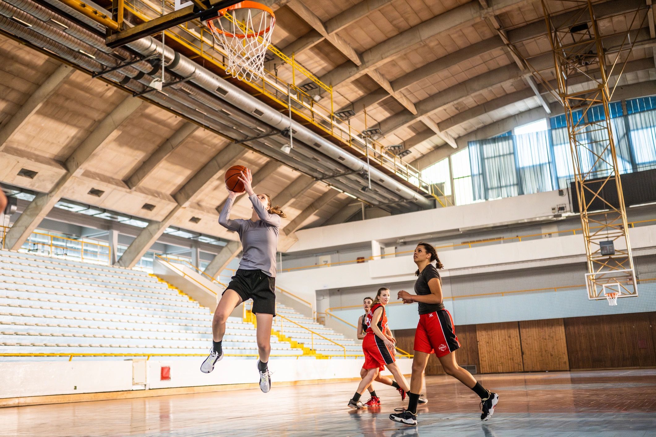 Basketball team shooting during indoor practice