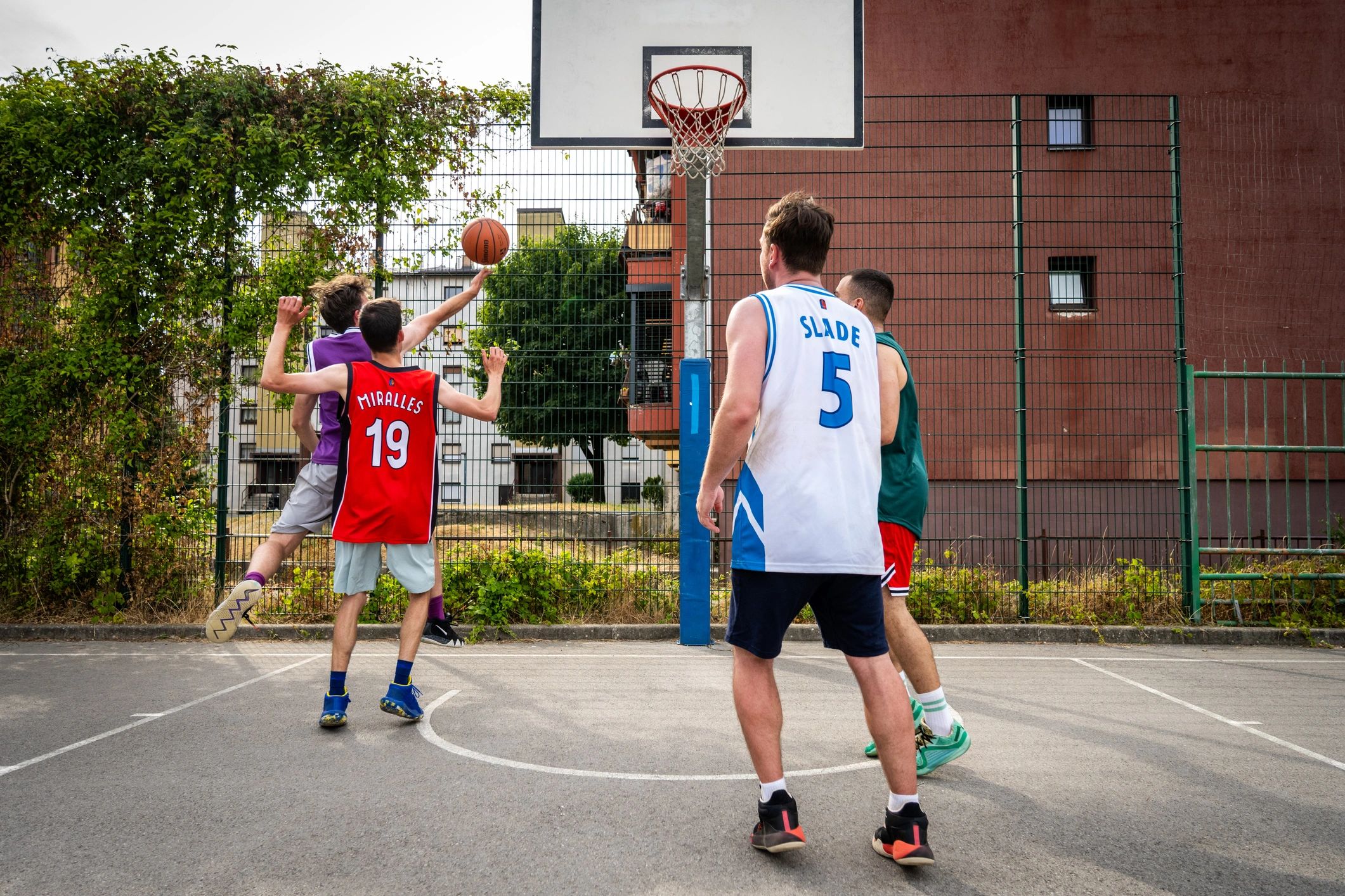 Basketball players competing during a game on an outdoor court
